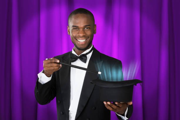 Young Happy Magician Showing Magic With Magic Wand And Hat